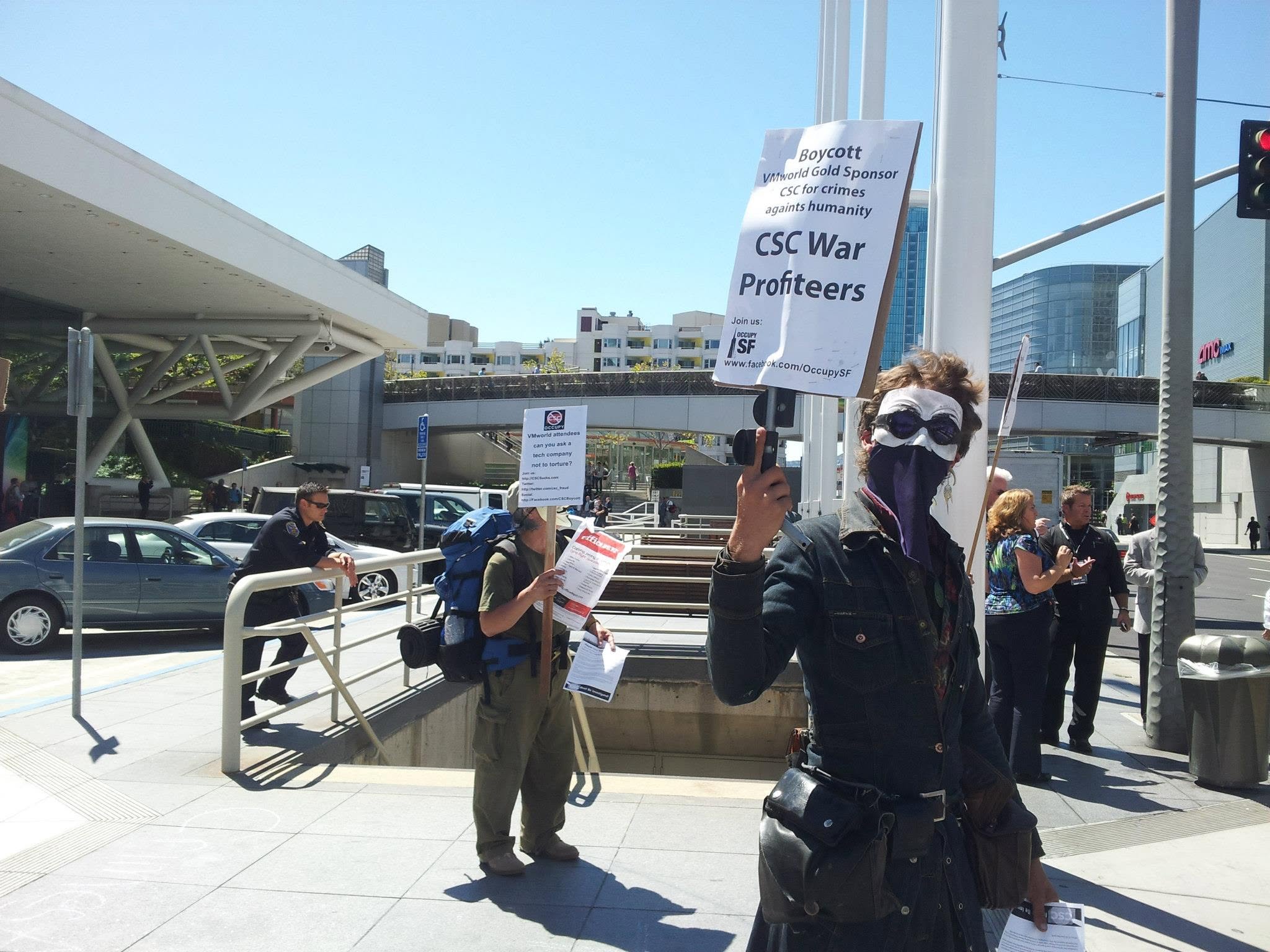Occupy San Francisco protester holding a sign reading Boycott VMworld Gold Sponsor CSC — CSC War Profiteers