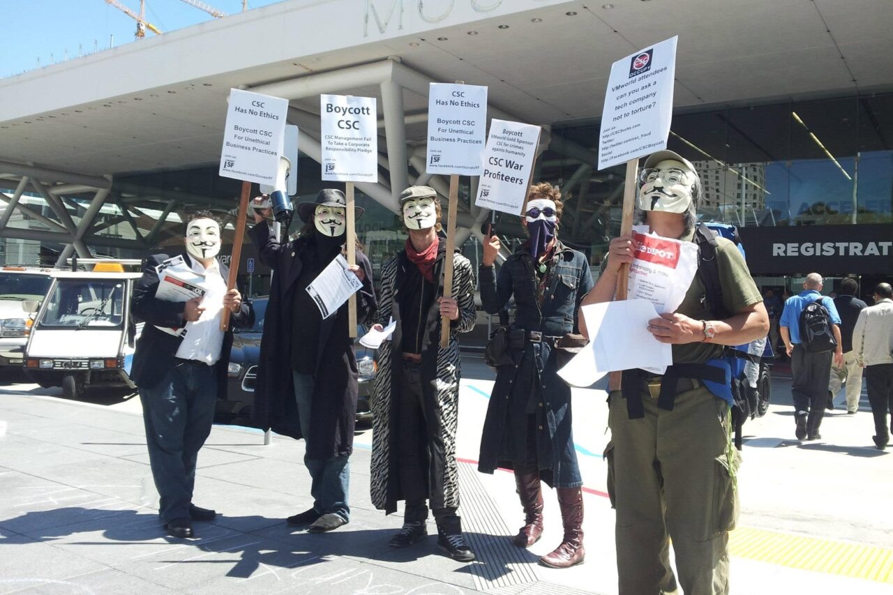 Occupy San Francisco protesters in Guy Fawkes masks outside Moscone Center holding Boycott CSC signs