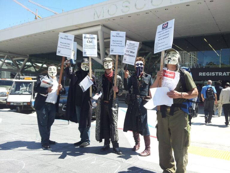 Occupy San Francisco protesters in Guy Fawkes masks outside Moscone Center holding Boycott CSC signs